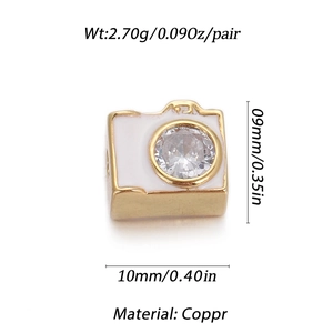 Dettaglio macro del ciondolo a forma di fotocamera dorata con smalto e zircone