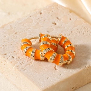 Detail of vintage enamel hoop earrings with orange stripes and gold-tone bamboo texture
