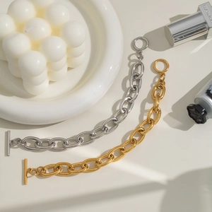 Close-up of gold and silver OT buckle chain bracelets with polished metallic finish