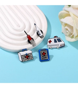 Detailed view of 5-piece medical enamel pin set with syringe, ambulance and first aid kit