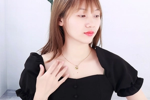 Detail shot of heart-shaped gold necklace on model showcasing a chic choker style