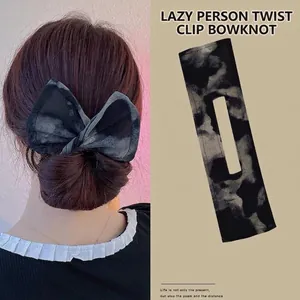 Detailed view of tie-dye bow hair curler showing fabric texture and model styling