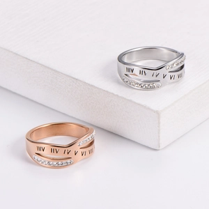 Minimalist Roman numeral rings in rose gold and silver with inlaid crystals on a white stand