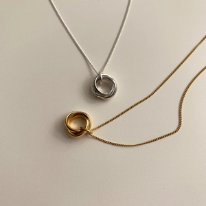 Detailed view of minimalist gold and silver intertwined triple ring necklaces on O-chains
