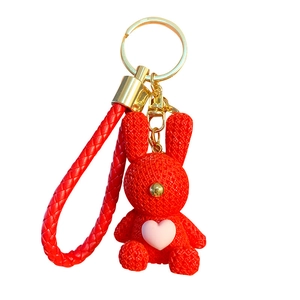 Red resin bunny keychain with diamond texture and gold ring on a white background