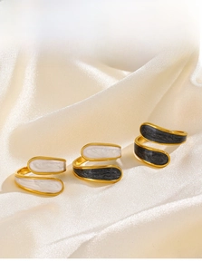 Detailed view of three 18K gold plated spiral rings with black and white enamel finish