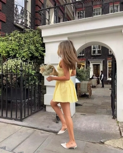 Vue arrière d'une robe courte jaune avec dos élastiqué et détails de dentelle élégante