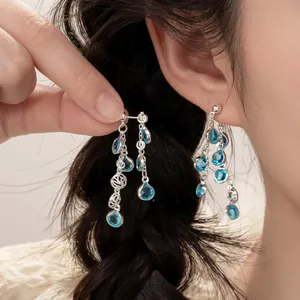 Boucles d'oreilles à pompons multicouches avec base argentée et perles bleues