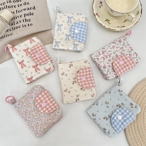 Detailed close-up of floral fabric mini wallets with snap buttons and portable clips