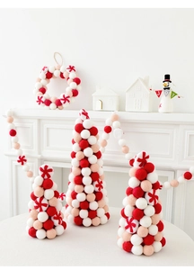 Three wool felt ball Christmas trees with matching garland and festive decor in red and pink