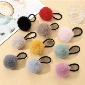 Detailed view of colorful faux fur pom pom hair ties with elastic rubber bands