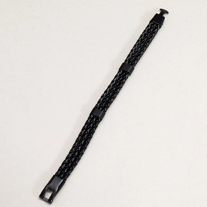 Detailed close-up of multilayered black woven leather bracelet with black metallic clasps