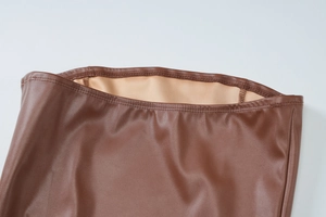 Detail eines dunkelbraunen Lederkleides mit hochwertigen Doppelnähten und beigem Futter