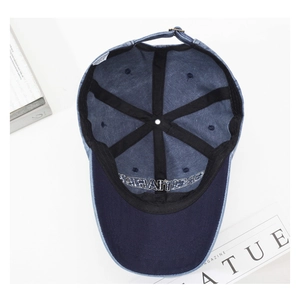 Detailed interior of blue denim baseball cap showing six-panel structure and metal buckle