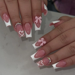 French tip press-on nails with pink 3D bows, white hearts and crystals on nude base