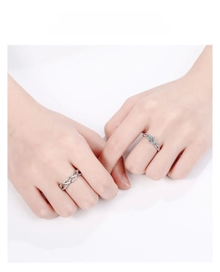 Detail of silver couple rings with braided design and sparkling zircon inlays for lovers