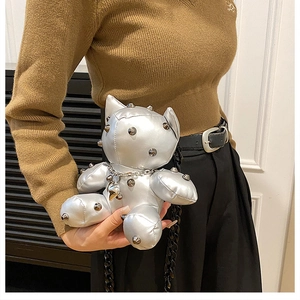 Detail of silver bear bag with metallic studs, chain and heart pendant accessory