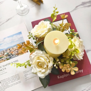 Centerpiece featuring a beige LED candle with white rose wreath on marble tabletop