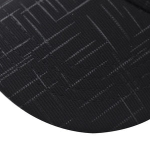 Detail of baseball cap brim showing grey geometric pattern and reinforced stitching
