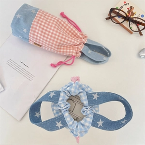 Detail of plaid cotton drawstring pouch with stars pattern and brand label on side