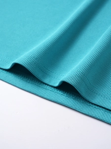 Detailed macro view of lake blue mesh fabric with professional stitching on the hemline