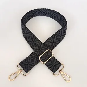 Close-up of gray geometric jacquard weave strap with polished gold metal swivel hooks