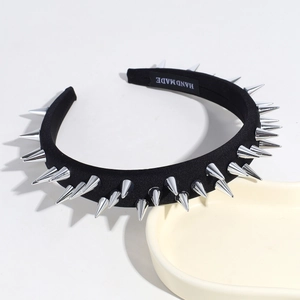 Close-up of black punk headband with silver metal rivets and handmade inner label