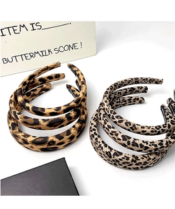 Top view of two padded leopard print headbands in brown and beige fabric finish