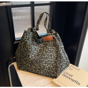 Detail shot of leopard print canvas tote with olive green pattern and external pocket