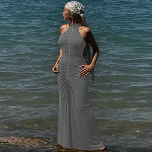 Detalle del vestido largo gris sin mangas con pliegues, botones y corte entallado