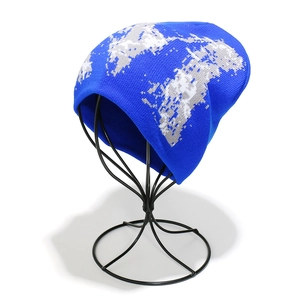 Détail du bonnet en tricot bleu avec motif de carte du monde pixélisé sur support