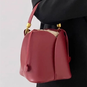 Elegant dark red leather bucket bag with gold hardware and beige drawstring inner pouch