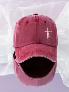 Detail of white faith cross embroidery on washed burgundy cotton baseball cap