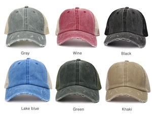 Close-up of washed cotton ponytail mesh caps showing distressed brims and various colors