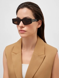 Macro detail of tortoiseshell sunglasses featuring gold metal accents on the temples