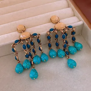 Vintage gold drop earrings with turquoise tassels and colorful gemstones in a velvet box