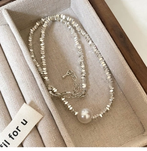 Detail of square silver link necklace with round white pearl in premium jewelry box