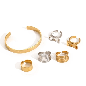 Poliertes Schmuckset aus Gold- und Silber-Edelstahl mit geometrischen Ringen und Armreif