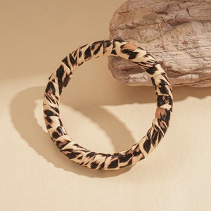 Close-up of leopard print wrap bangle showing texture on natural stone background