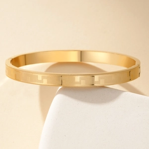 Gold titanium steel bracelet with geometric Greek key pattern and secure clasp closure