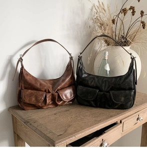 Close-up of vintage faux leather baguette bags with dual front pockets in brown and black