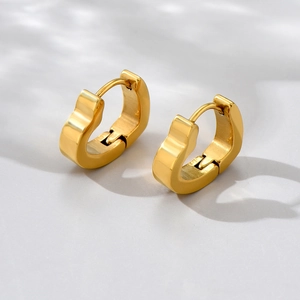 Close-up of heart-shaped gold titanium steel hoop earrings with secure latch closure