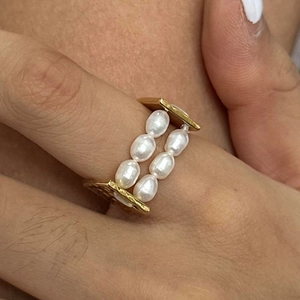 Dettaglio ravvicinato di un anello a doppia fila di perle in oro 18k martellato