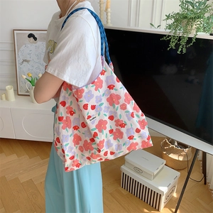 Detailed shot of the floral fabric tote bag featuring long handles and Szakka brand label