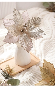 Champagne velvet poinsettia in a white vase on a warm knit blanket for Christmas decor