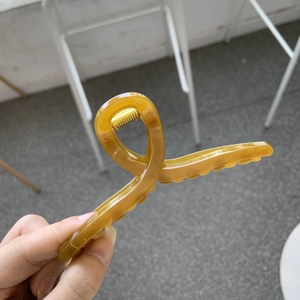 Detailed view of an 11cm amber hair claw clip with a transparent finish and gold spring