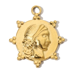 Macro detail of a vintage gold-plated pendant featuring a classical portrait relief design