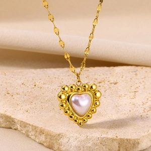 Detail of vintage gold plated heart necklace with pinkish white pearl pendant inlay