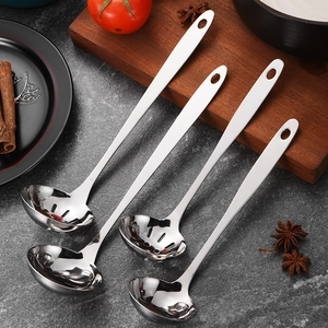 Thick stainless steel soup ladle and colander set on a rustic kitchen tabletop