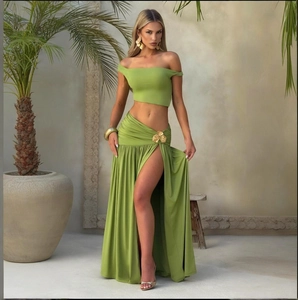 Detail of green two-piece set featuring off-shoulder top and high-slit floral skirt